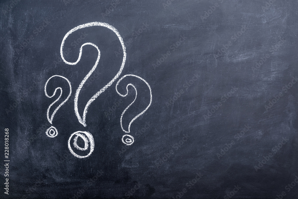 Three white question mark drawn on chalkboard