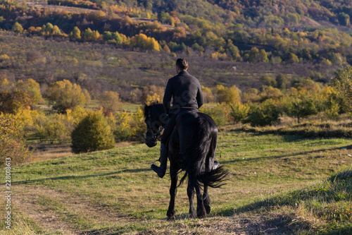 A beautiful connection between a equestrian and his black horse on a sunny autumn day.