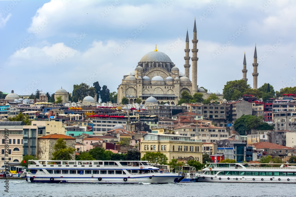 Obraz premium Touristic landmarks from sea voyage on Bosphorus. Cityscape of Istanbul at sunset - old mosque and turkish steamboats, view on Golden Horn.