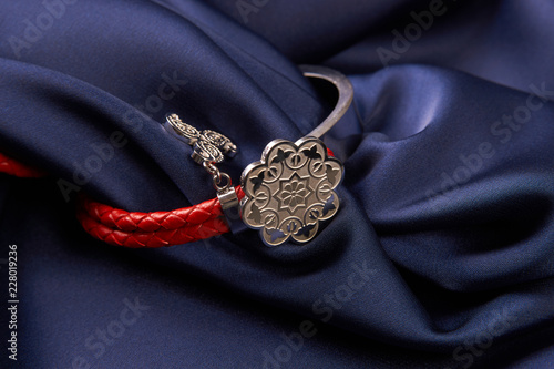 Pair of two Jewelery bijouterie rings with red leather on blue silk background with copy space, Beautiful precious women's jewelry, close-up