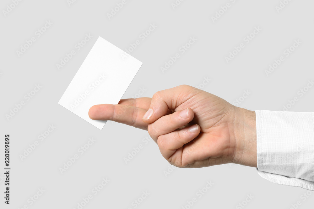 Mockup of male hand holding a Business Card isolated on light grey background. Europe standard size 85x 55 mm. Mockup of male hand holding a Business Card isolated on light grey background. Europe standard size 85x 55 mm.