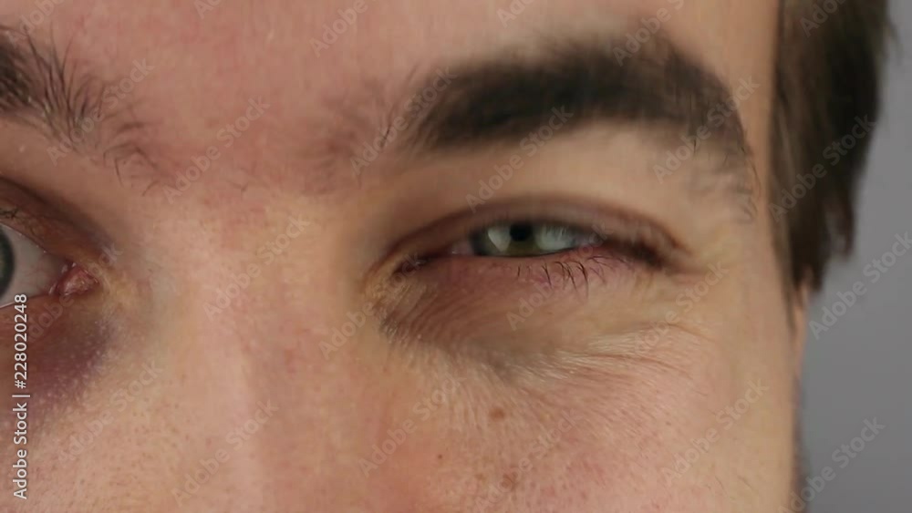 man blinks raising his eyebrow, left eye, closeup man blinks raising his eyebrow, left eye, closeup