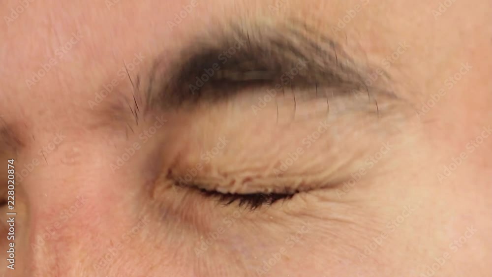 eye opens wide in panic, fear and horror, then eye closes and highly compressed the eyelid, closeup eye opens wide in panic, fear and horror, then eye closes and highly compressed the eyelid, closeup