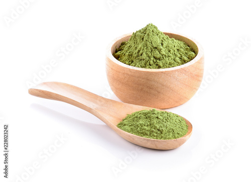 Wooden spoon with powdered matcha green tea in bowl
