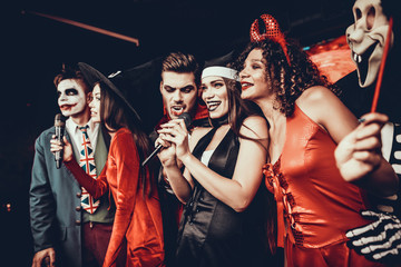 Young People in Halloween Costumes Singing Karaoke