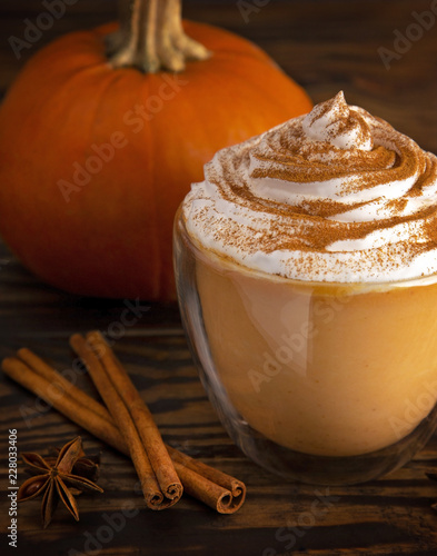 APumpkin Spice Latte in a Clear Mug on a Wooden Table photo