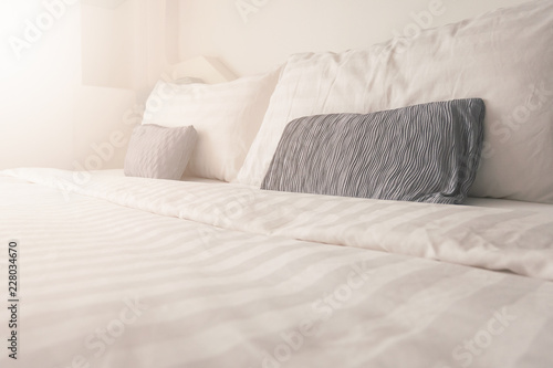 Bedding in bedroom with sunrise effect,clean white bedding sheet and pillows in beauty room interior