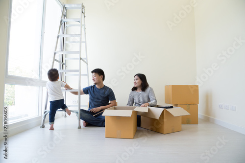 Happy Asian family with cardboard boxes in new house at moving day, Real estate and home concept