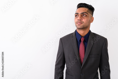 Young Indian businessman wearing suit against white background