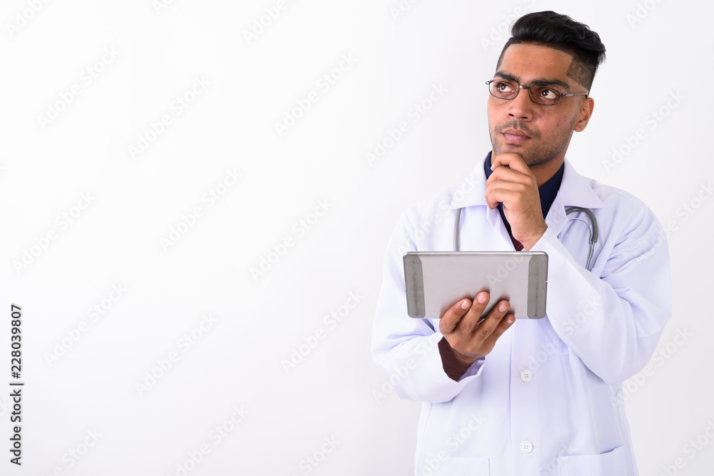 Young Indian man doctor wearing eyeglasses against white backgro Young Indian man doctor wearing eyeglasses against white backgro