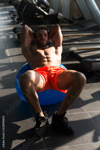 Young Man Doing Abdominal Exercise On Ball