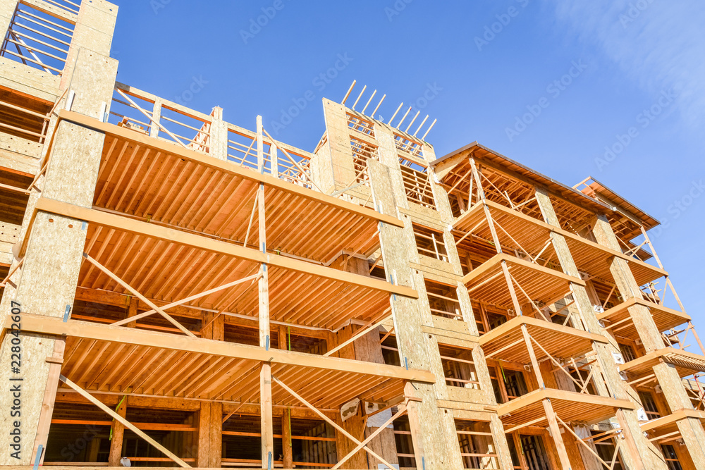 Obraz premium Six storey frame building under construction on blue sky background