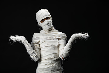 Studio shot portrait  of young man in costume  dressed as a halloween  cosplay of scary mummy pose like a open hand acting on isolated black background