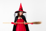Woman in red dress costume for famale witch holding broomstick on white background. Concept for funny activity in halloween festival
