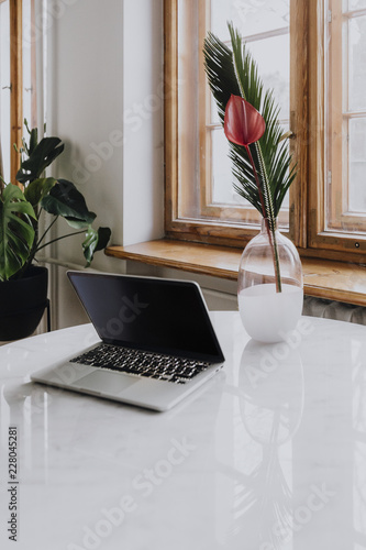 Laptop and a vase on a marble table