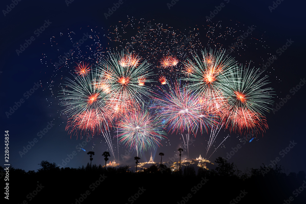 Firework display festival ..The most famous firework Pra Nakorn Kiri festival in petchaburi Thailand with palm tree silhouette in foreground and three pagodas on the hill in background.