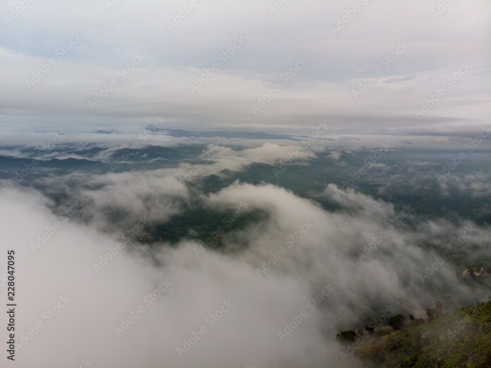 Aerial view of nature scenery. An aerial shot of hill with cloudy and misty background. Aerial view of nature scenery. An aerial shot of hill with cloudy and misty background.