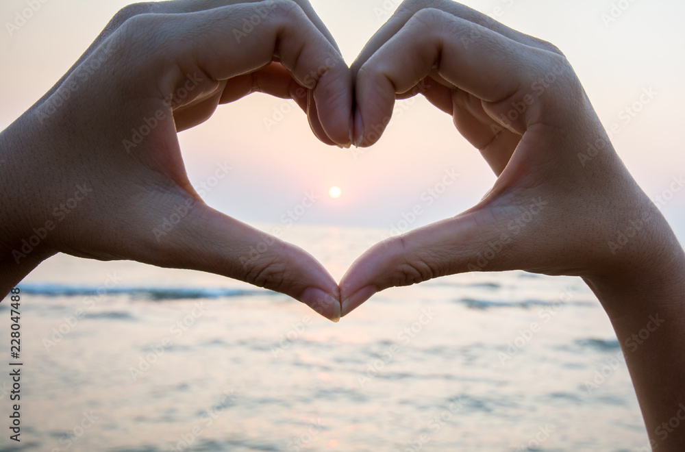 Obraz premium heart from hands of couple on the beach