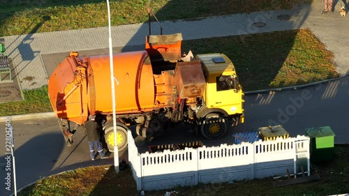 A garbage truck cleans garbage cans in the courtyard of a residential area from garbage and takes it to landfill, garbage truck photo