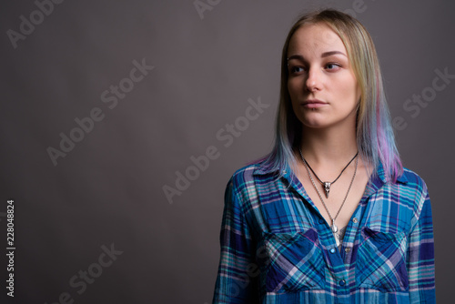 Young beautiful rebellious woman with multicolored hair against 