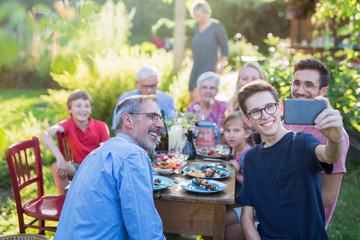 during a bbq a boy does a selfie with the whole family