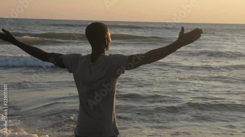 Wallpaper Mural Nature, spirituality, well-being. African man opening his arms on the beach Torontodigital.ca