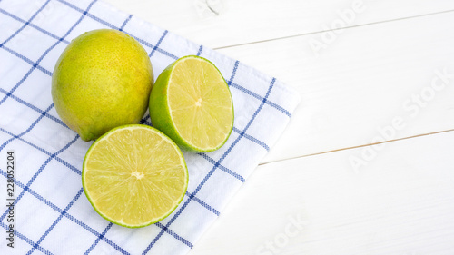 Картината върху платно Green lime on a white wooden table.