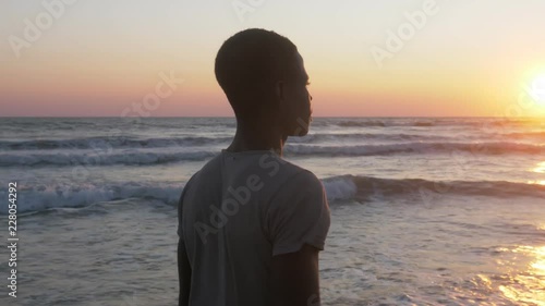 young African refugee looking the sea.Missing home, Africa,migration photo