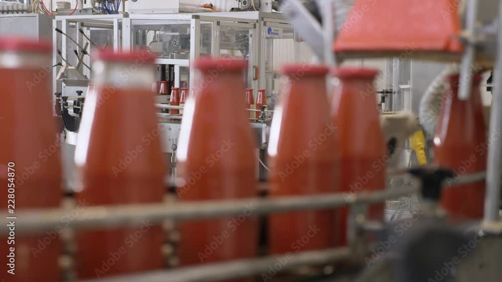 Tomato sauce factory: tomato sauce bottles running on conveyor line Tomato sauce factory: tomato sauce bottles running on conveyor line