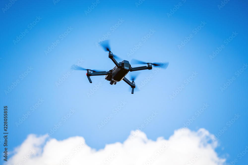 Quadrocopterfor shooting video in a blue sky with white clouds_ Quadrocopterfor shooting video in a blue sky with white clouds_