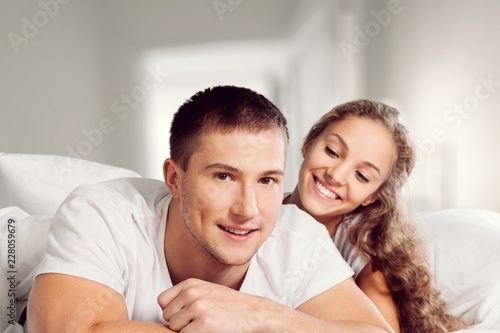 Young beautiful couple sleeping in white bed