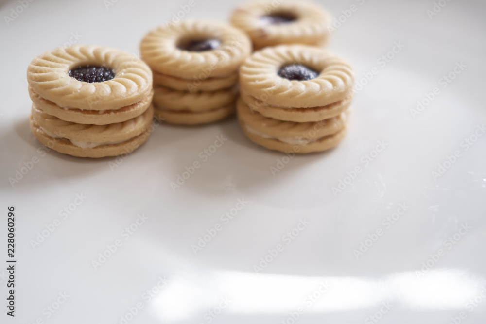 TART SANDWICH COOKIES WITH CREAM & STRAWBERRY FLAVORED JAM. selective focus. light leak effect TART SANDWICH COOKIES WITH CREAM & STRAWBERRY FLAVORED JAM. selective focus. light leak effect