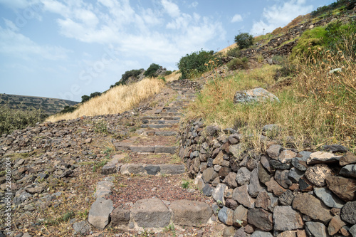 A path  with stairs in ruins of the ancient Jewish city of Gamla on the Golan Heights destroyed by the armies of the Roman Empire in the 67th year AD photo