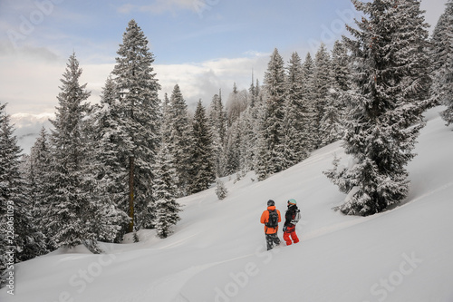 Two snowboarders standing in the mountain resort