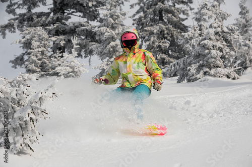 Girl running down the mountain slope on the snowboard