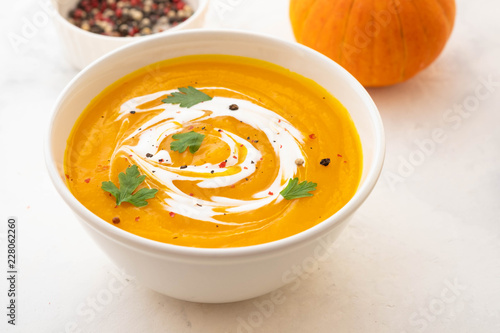 Pumpkin soup with cream and pumpkin seeds isolated on white background. Autumn concept.