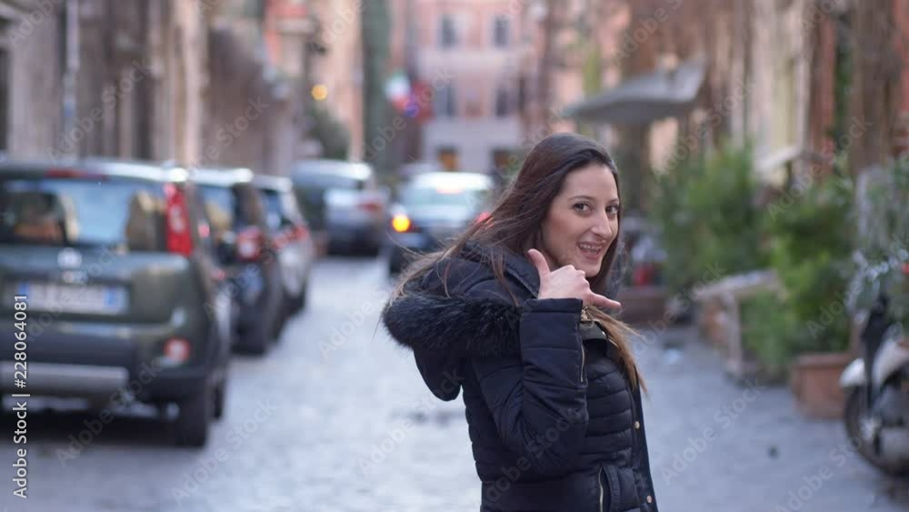 calls, exhortation.woman walks down the street and makes phone gesture calls, exhortation.woman walks down the street and makes phone gesture