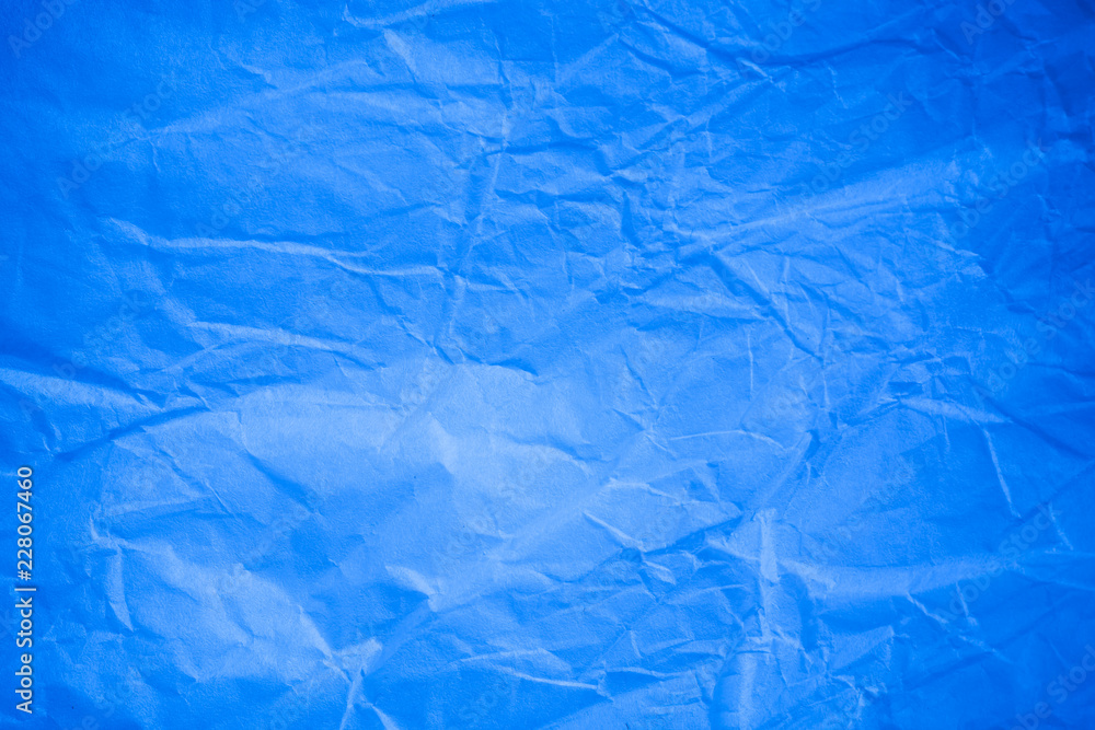 Obraz premium Crumpled blue paper background.