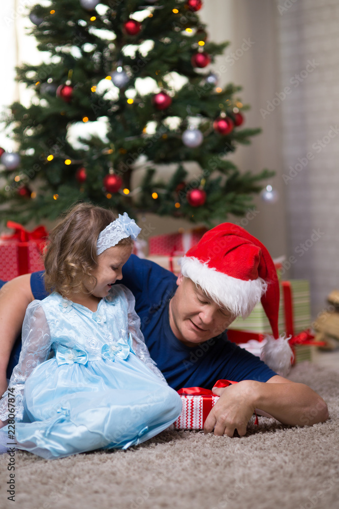 Dad and daughter under the Christmas tree Dad and daughter under the Christmas tree
