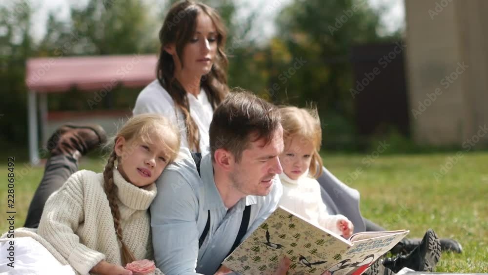Happy Family Sitting On a Grass During Summer Rest on The Lawn. Full HD Happy Family Sitting On a Grass During Summer Rest on The Lawn. Full HD
