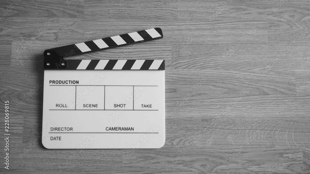 Obraz premium Clapper board or clap board or movie slate use in video production , film, cinema industry. It's white color on wood background.