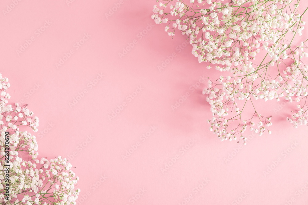 Obraz premium Frame made of small white flowers on pastel pink background. Happy Women's Day, Wedding, Mother's Day, Easter, Valentine's Day. Flat lay, top view, copy space 