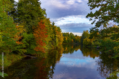 Peaceful calm autumn pond with colorful reflection