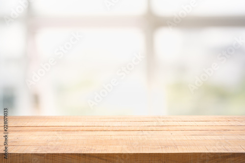 Blur background of white window glass and green view from garden with empty of wood table.