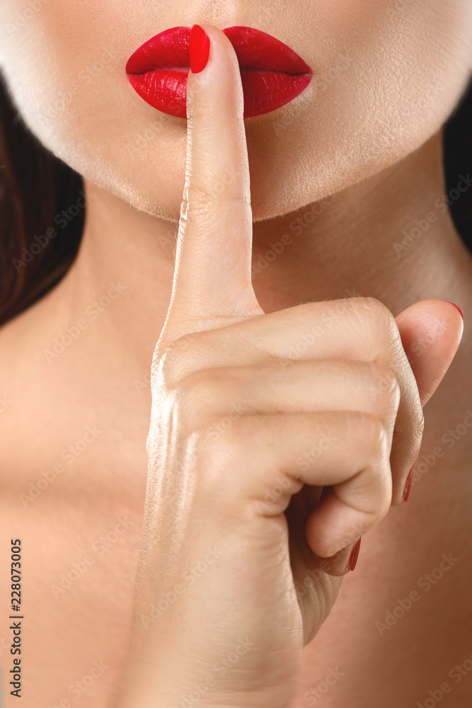 Fototapeta premium Kobieta pokazuje gest uciszenia lub ciszy