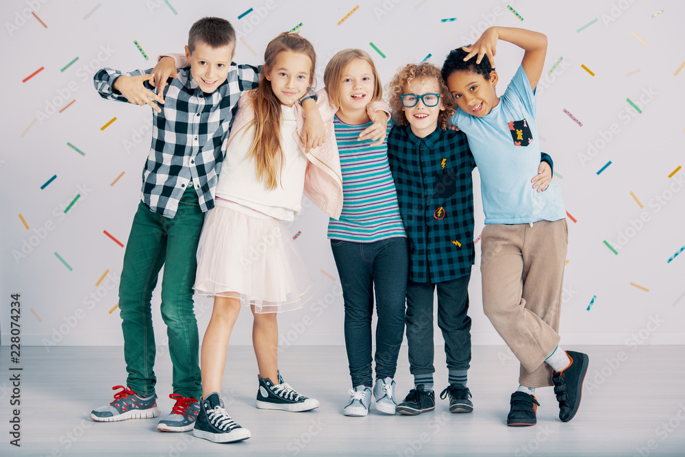 Fototapeta premium Happy multicultural group of kids have fun against colorful wallpaper
