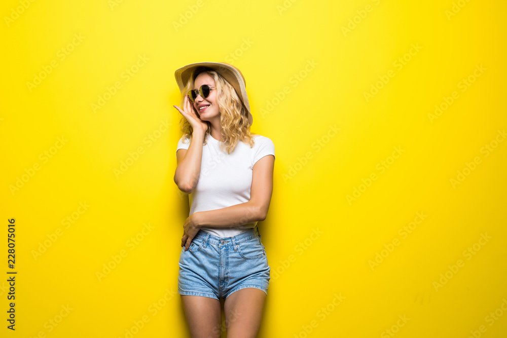 Portrait young woman wearing straw hat posing over colorful yellow background Portrait young woman wearing straw hat posing over colorful yellow background