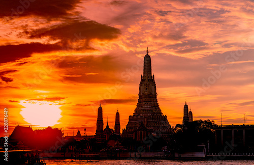 Wat Arun Ratchawararam at sunset with beautiful  orange sky and clouds. Wat Arun buddhist temple is the landmark in Bangkok  Thailand. Attraction art and ancient architecture in Bangkok  Thailand.