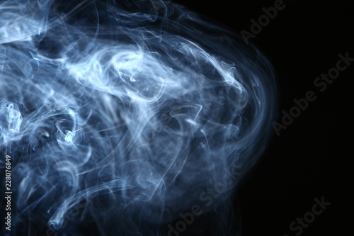 lovely flowing glowing blue smoke against the heavy black background.