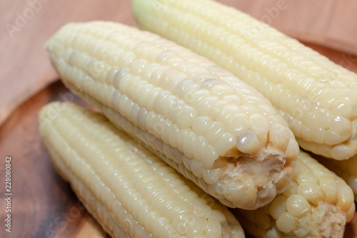 close up of waxy corn in wooden plate photo